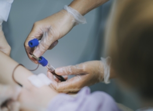 Medical professional taking a blood sample from a patient in a hospital setting